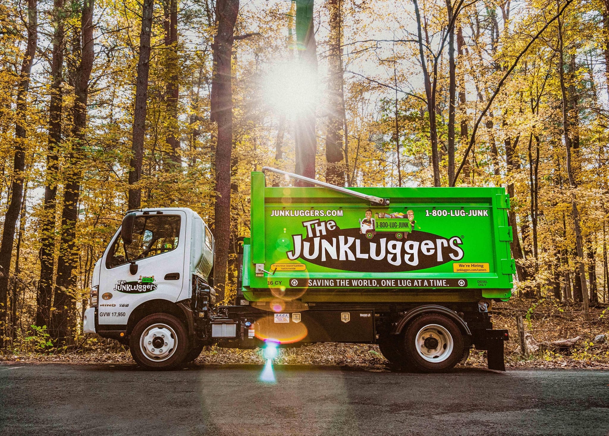 green truck in front of trees and leaves